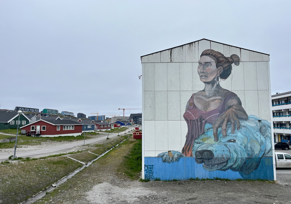 Straßenkunst in Nuuk vor arktischer Kulisse.